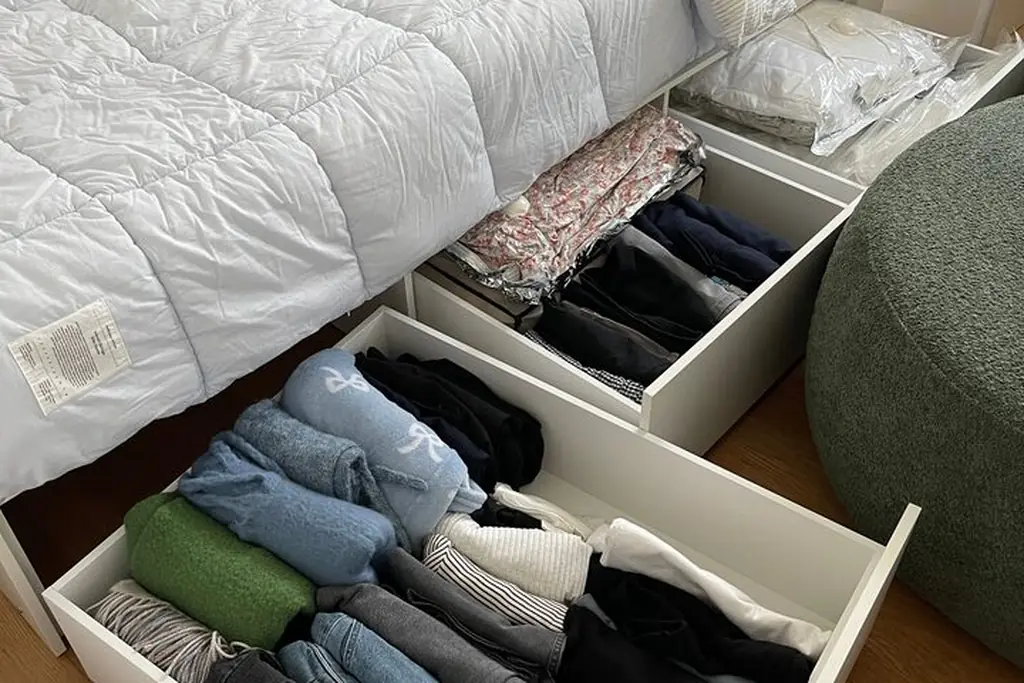 Flat labelled storage bins on top of a wardrobe holding out of season items.