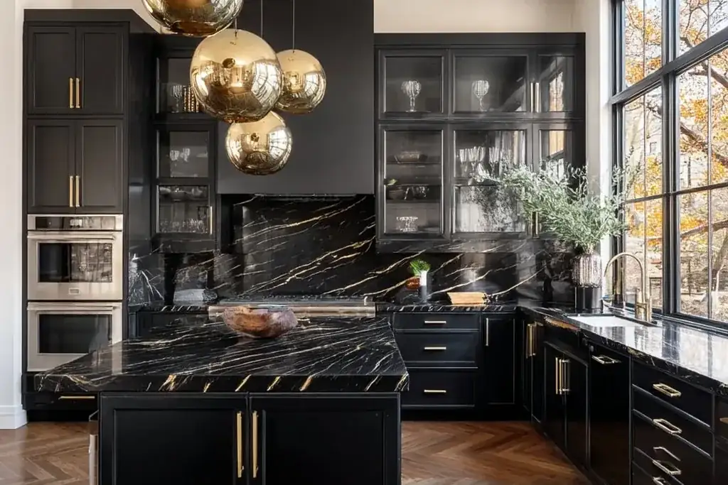 Black kitchen where gold pendants, cabinet pulls and faucet repeat across the room.