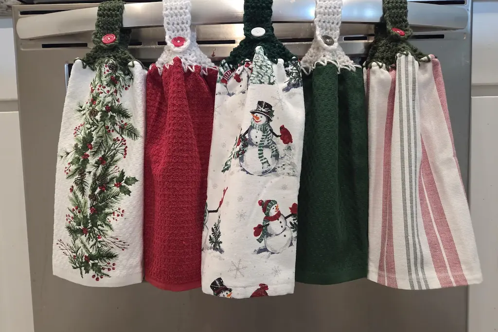 Christmas themed kitchen towels hanging from an appliance handle.