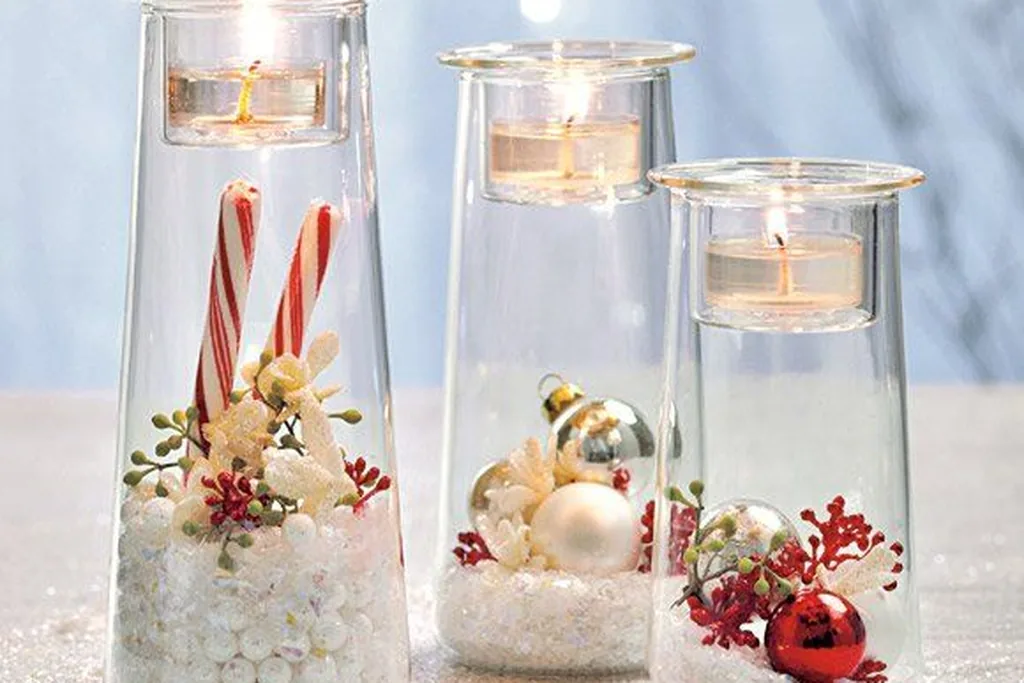 Glass hurricane vases with floating candles, candy canes, and small ornaments.