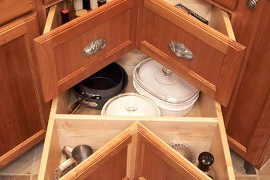 Stack of L shaped corner drawers opened in a kitchen base cabinet.