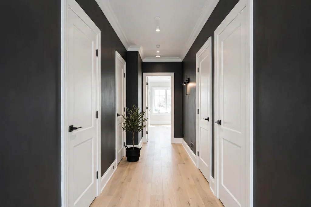 Hallway with charcoal walls, white trim and doors, and a pale floor.