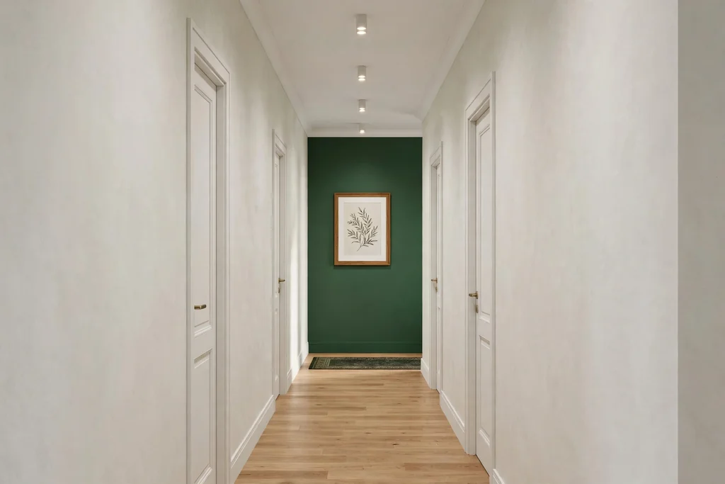 Long hallway with pale side walls and a deep green wall at the far end.
