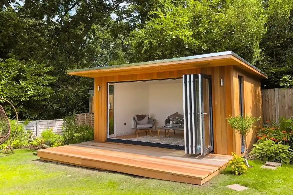 Garden studio with wide glass doors opened onto a small deck.