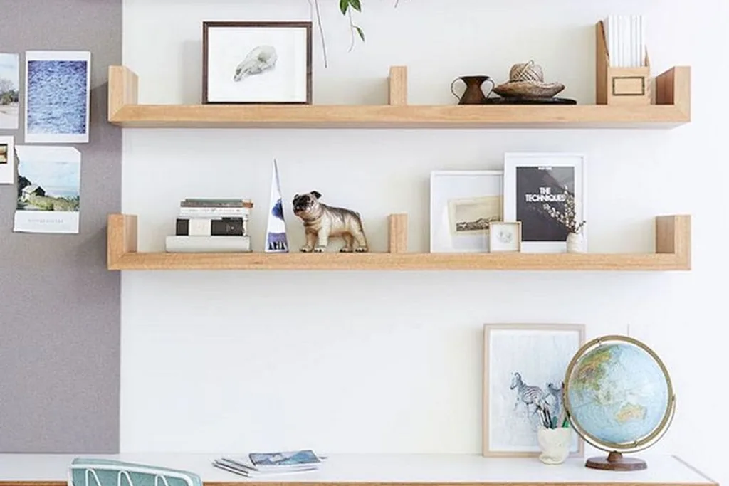 Open wood shelves mounted above a white studio desk.