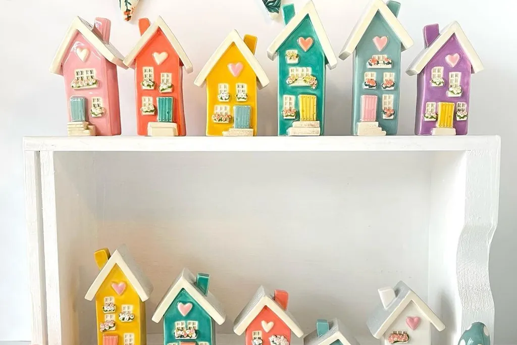 Small ceramic houses arranged on a shelf.