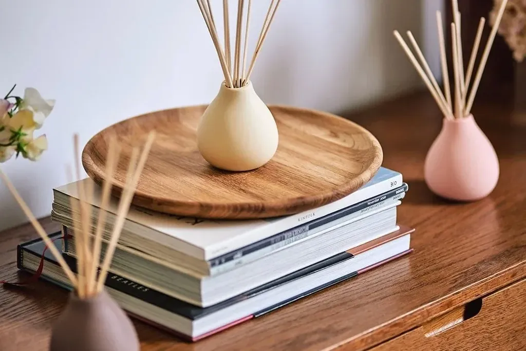 Reed diffuser on a tray on a dresser.