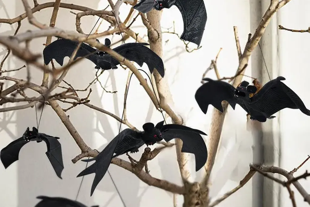 Branch in a vase with paper bats and stars.