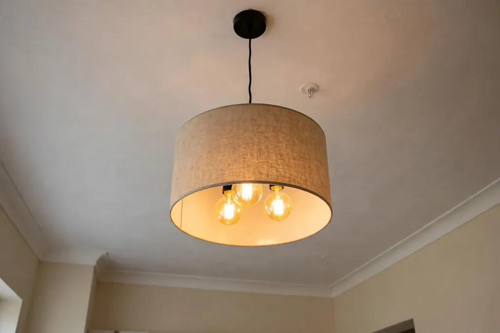 Living room ceiling with a new simple drum pendant light fixture.