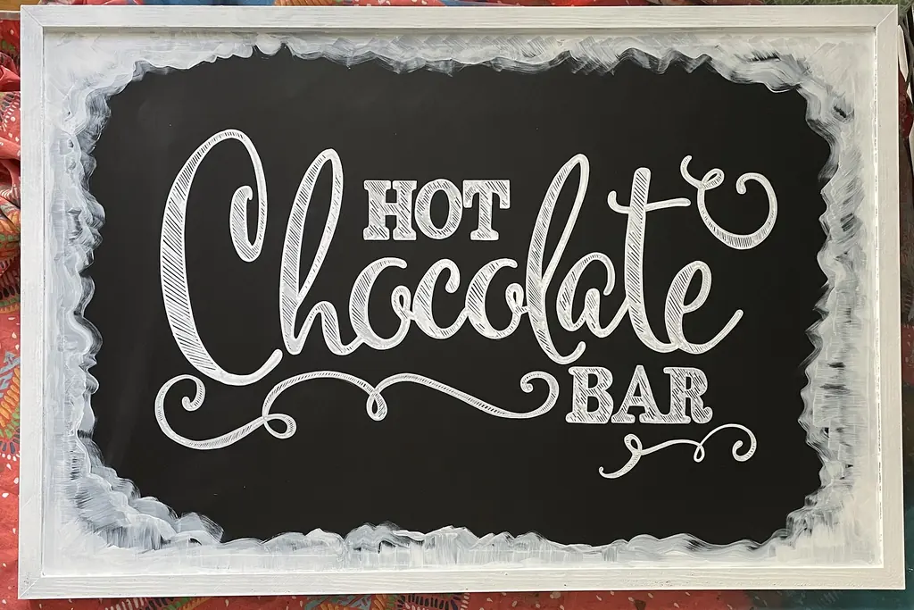 Chalkboard sign with Hot Chocolate Bar written in white chalk lettering.