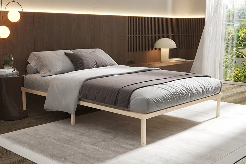 Low wood bed frame with simple bedding in a small bedroom