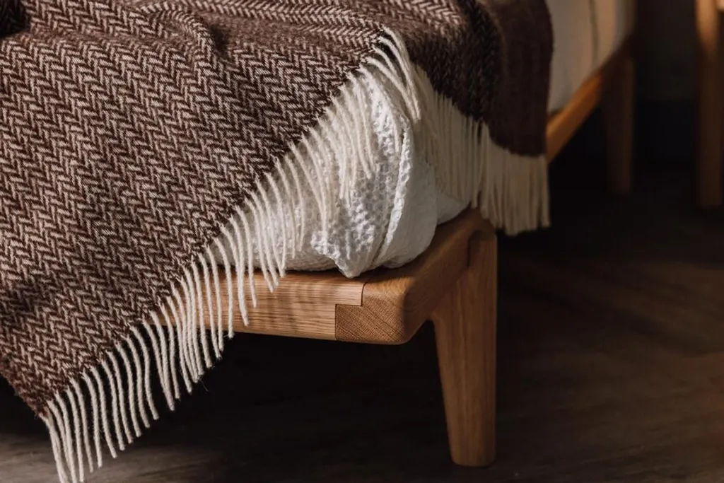 Folded wool throw across the foot of a bed