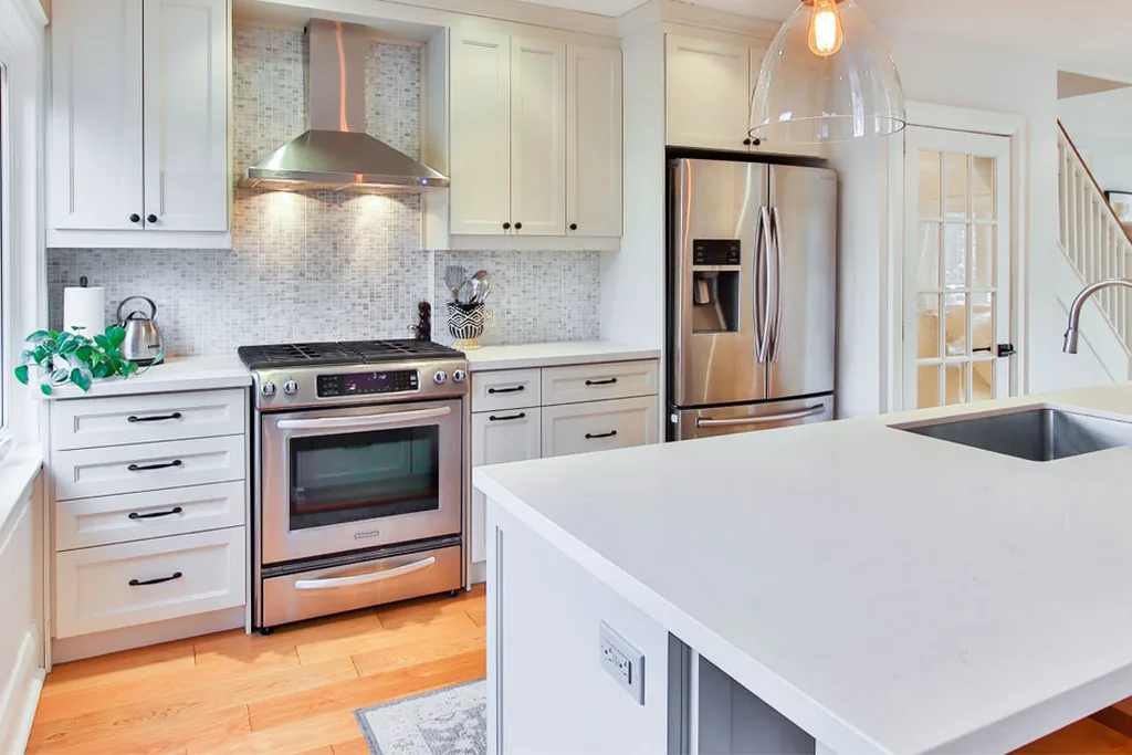 Kitchen with classic white cabinets and a marble look countertop.