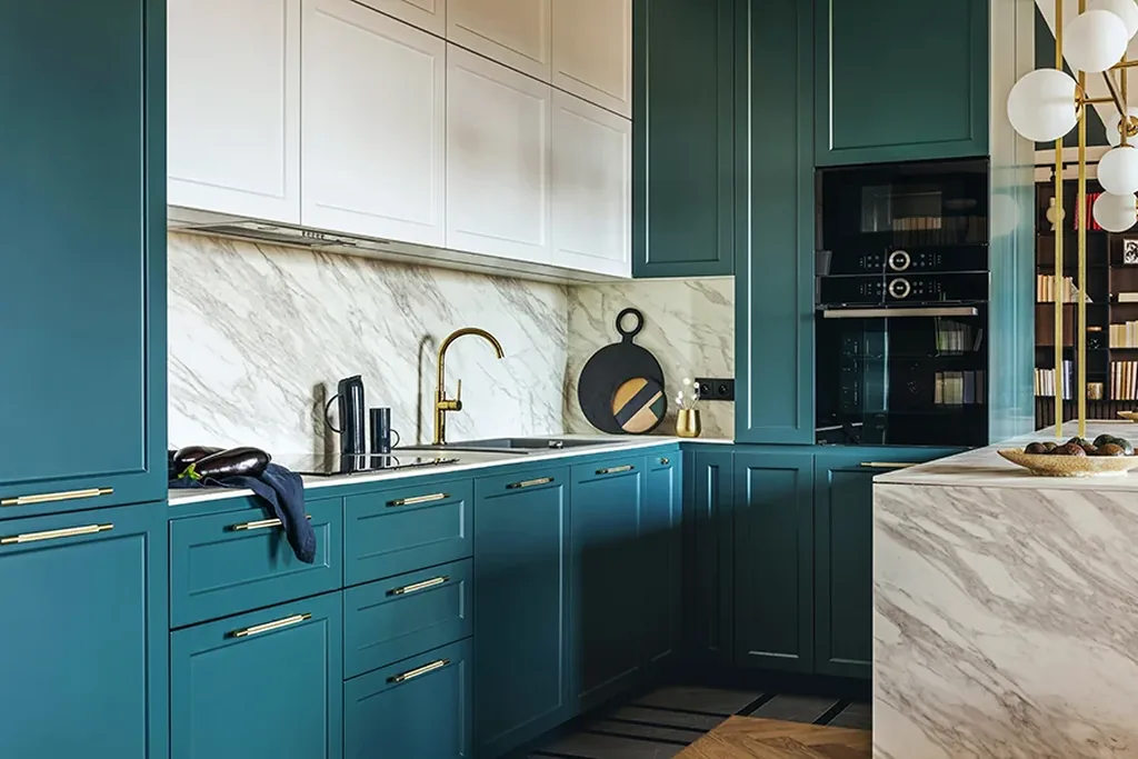 Kitchen with deep teal cabinets and warm metal handles.