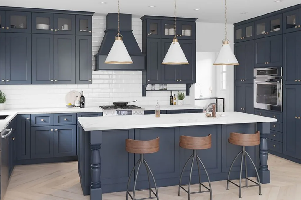Kitchen with ink blue cabinets, a white island counter and wood stools.