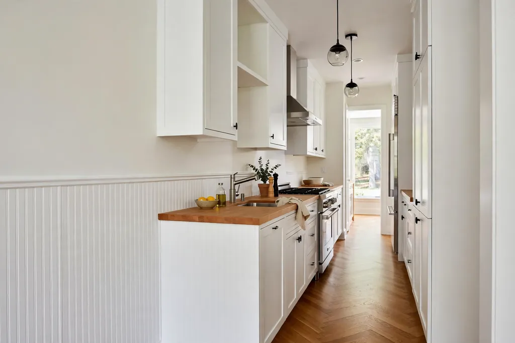 White beadboard panelling on the lower half of a long narrow kitchen wall.
