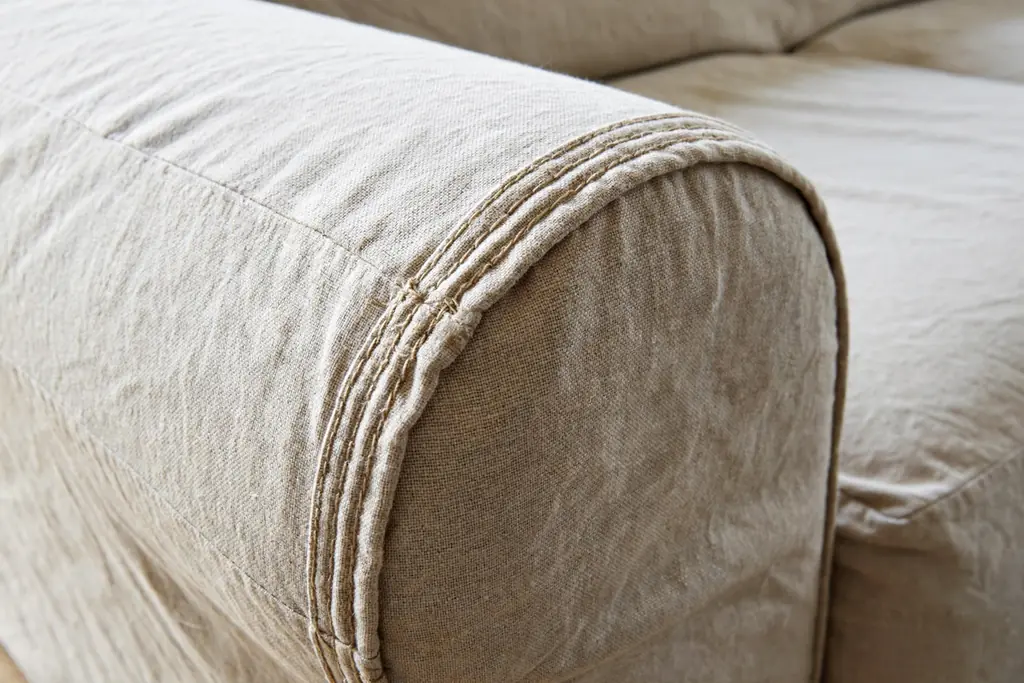 Close view of a reinforced double stitched seam on a sofa arm slipcover.