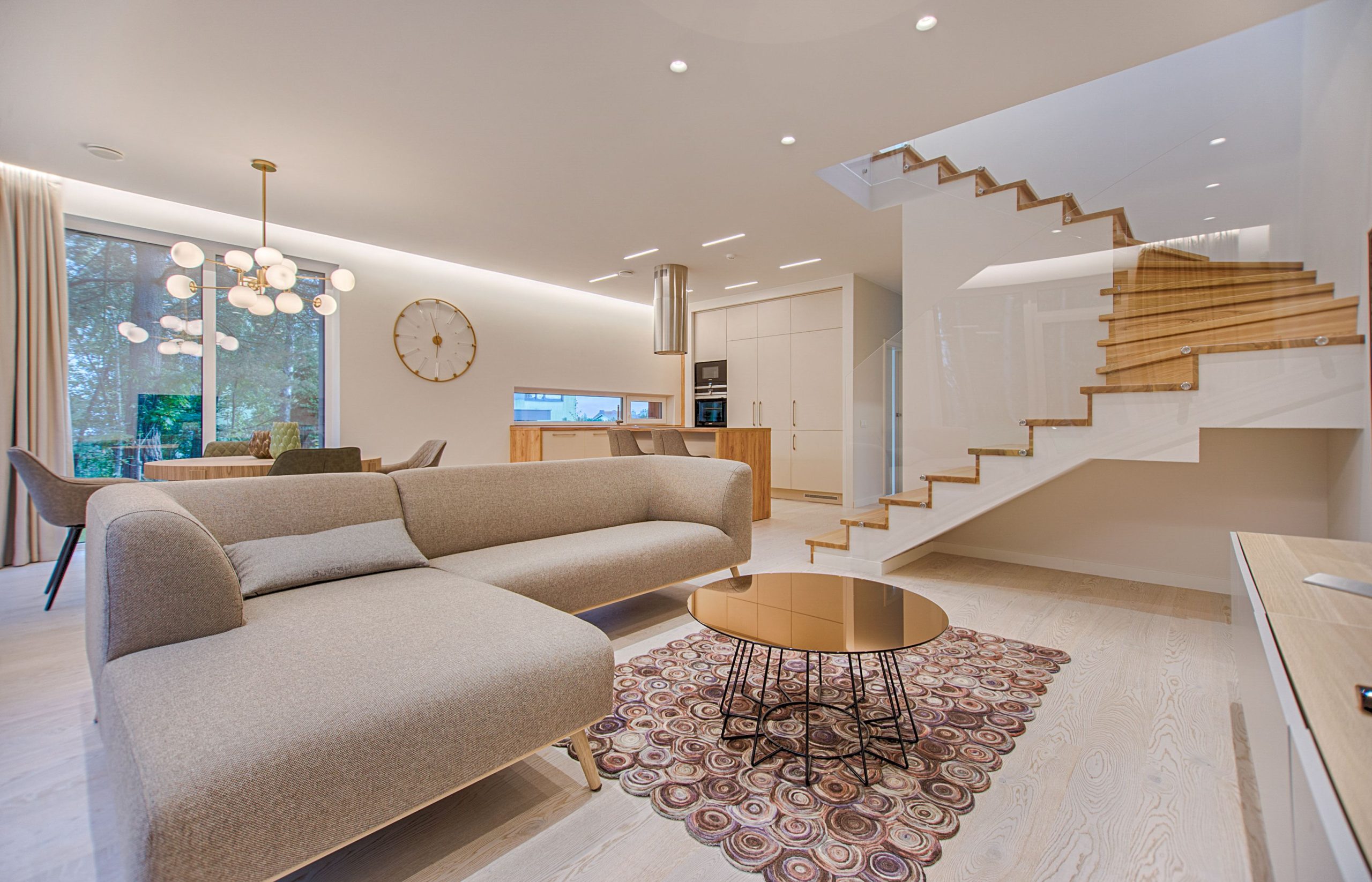 Bright, welcoming living room with neutral seating, greenery, and natural light