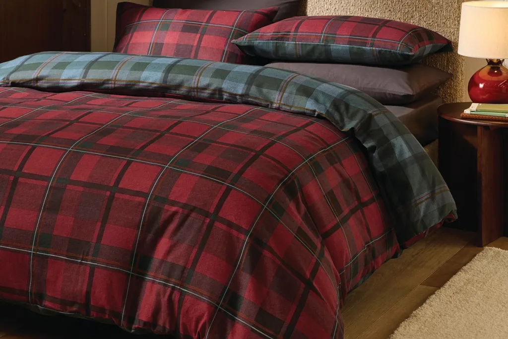 Tartan plaid duvet cover in red and navy as the focal point of a bedroom with white sheets