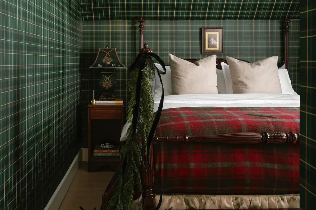 Painted plaid effect wall in soft sage tones behind a bed