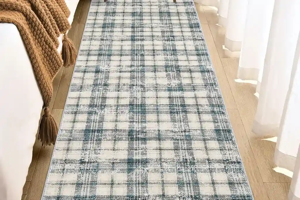 Narrow plaid runner rug laid along the side of a bed in a small bedroom