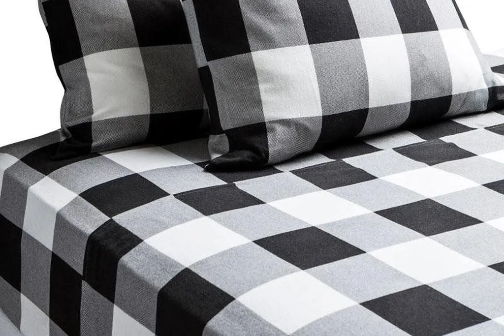 Buffalo check throw folded across the foot of a bed with plain white bedding