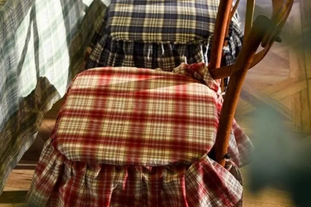 Bedroom chair with a plaid fabric seat pad at a plain dressing table