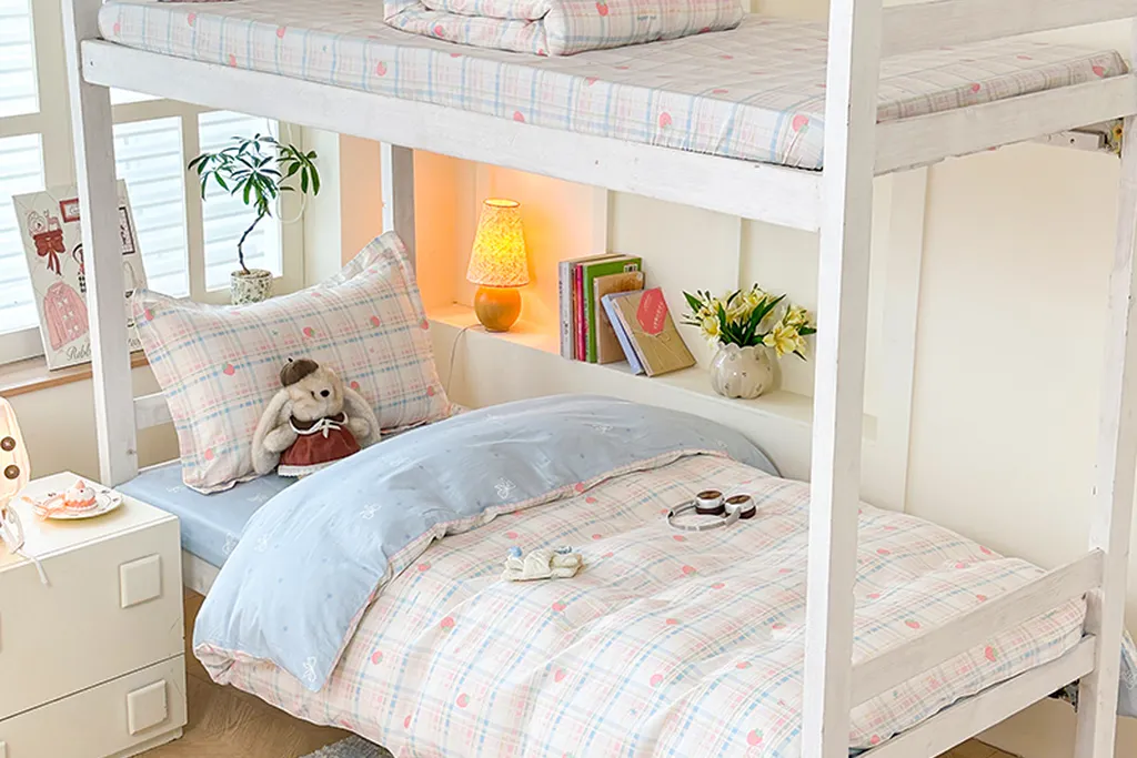 Child bedroom bed with a plaid duvet cover and one plaid cushion