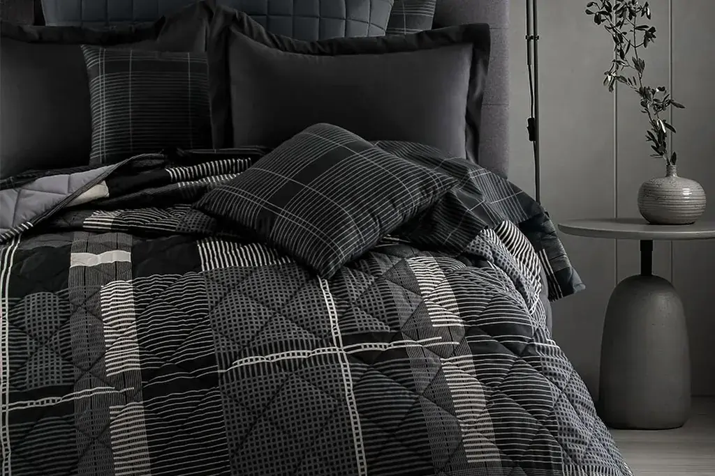 Tonal charcoal plaid duvet cover on a bed in a modern bedroom with plain walls