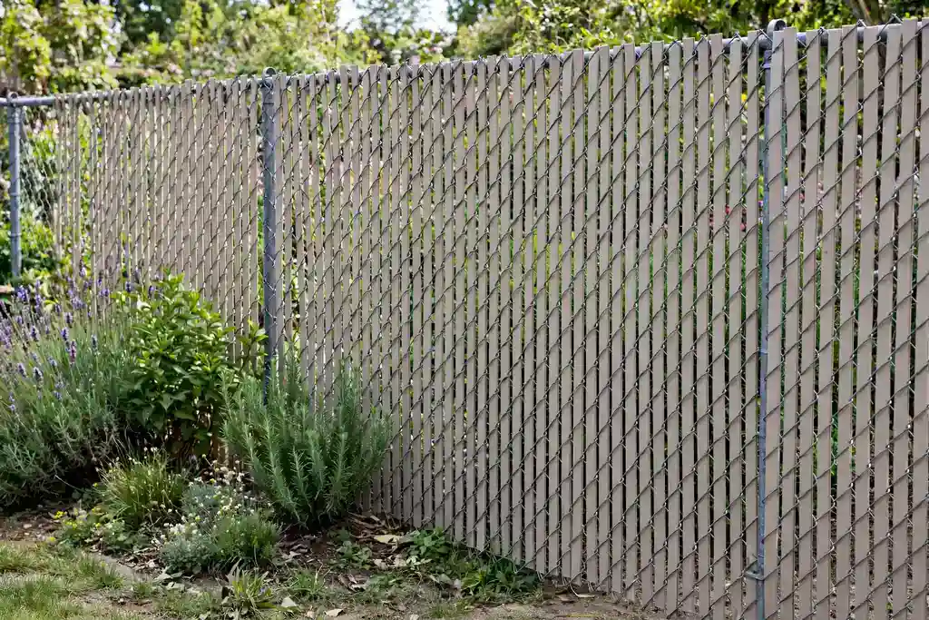 Chain link fence with privacy slats threaded through the mesh.