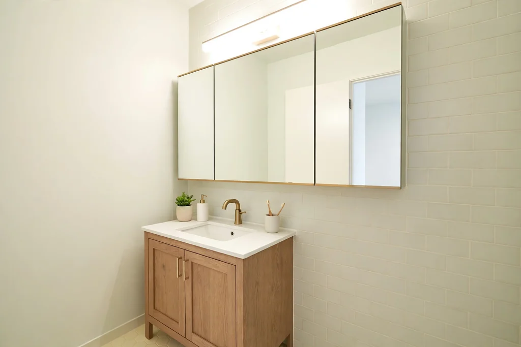 Small bathroom vanity with a large mirrored medicine cabinet above the sink.