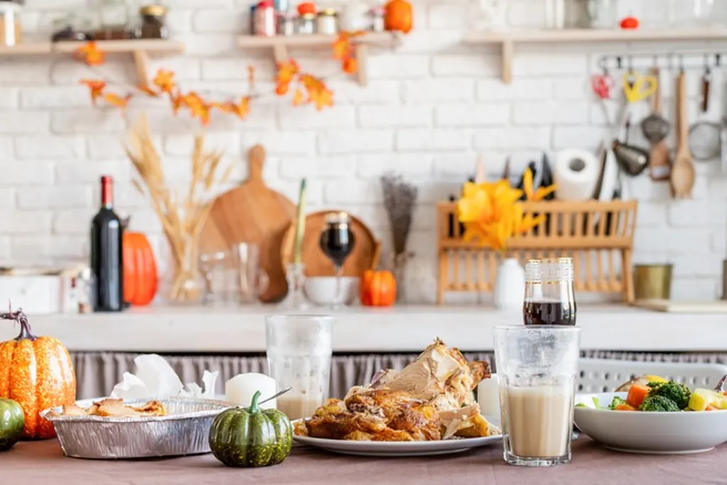 Kitchen counter styled in one zone with pumpkins, dishes, and a fall garland.