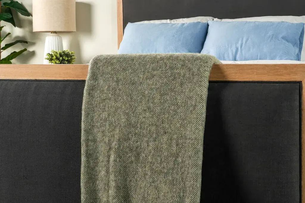 Wool throw folded across the foot of a bed.