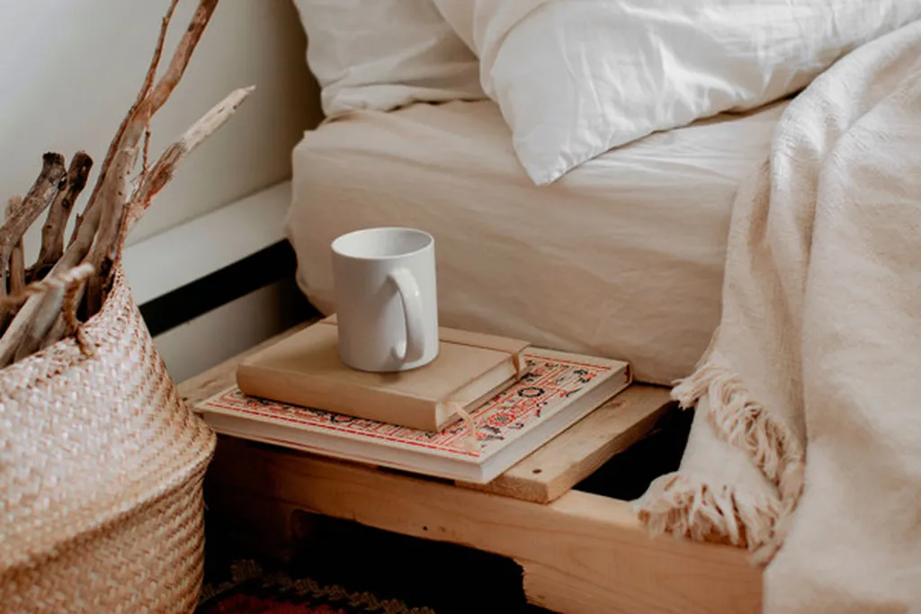 Tray with a mug and a book on a bedroom dresser.